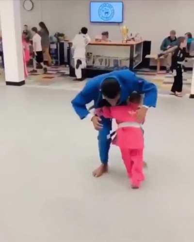 Instructor teaching little girl some ground techniques