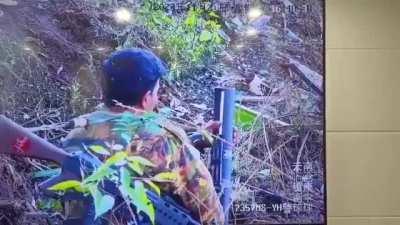 Chinese border guards watching a Myanmar Junta soldier's weapons malfunction through CCTV