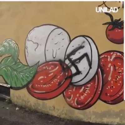 This guy covering racist graffiti with food