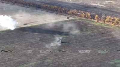 Russian BMP drives across a field towards a treeline to drop off infantry while laying down suppressive fire, north of Bohoyavlenka