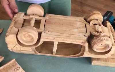 Hand carving a Land Cruiser from a block of wood.