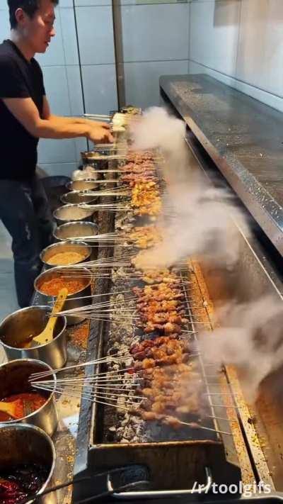 Commercial kitchen downdraft extractor next to an indoor charcoal grill