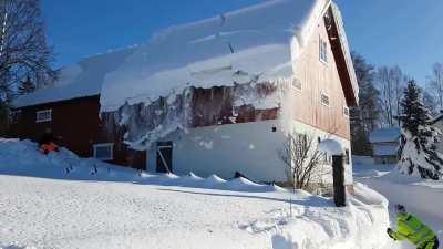 Using a length of rope to clear the snow from a roof