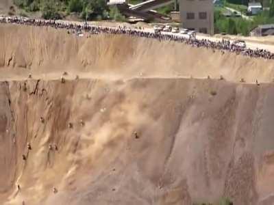 A Group Riding Dirt Bikes Up a Vertical Steep Hill