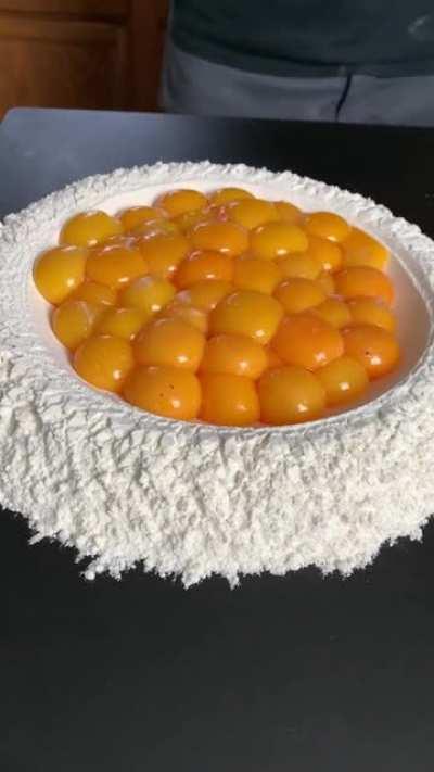 The way the chicken eggs and ostrich egg is poured over flour