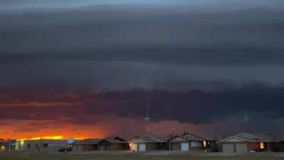 Enormous shelf cloud and storm in front of a sunset