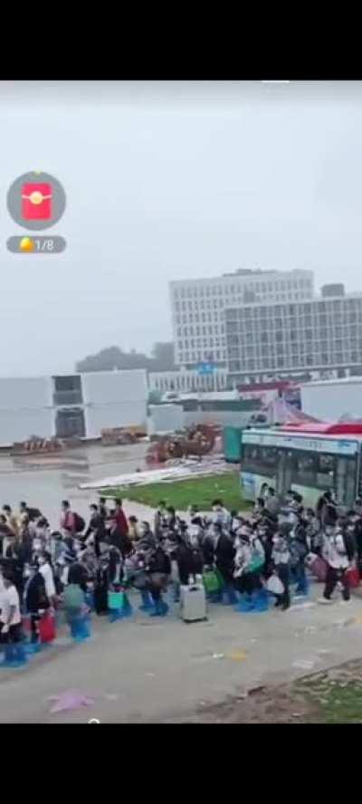 Huge crowds arriving by bus to an isolation camp in the city of Guangzhou