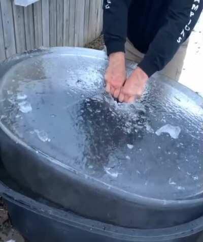 Pulling ice out of a water tub on a Canadian winter morning