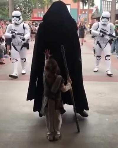 This kid stood still as the parade of Dark Sith with clone troopers passes.