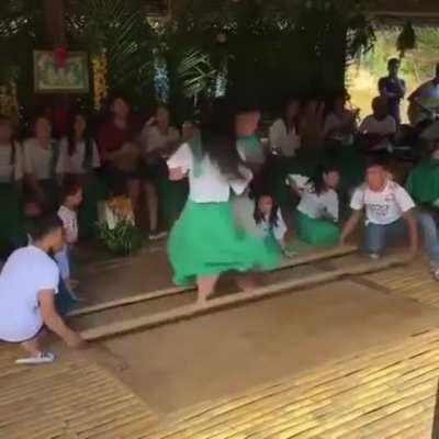 Young dancers in the Philippines performing a traditional bamboo dance known as Tinikling.