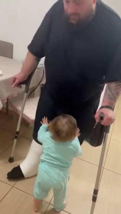 Toddler helps dad to sit down