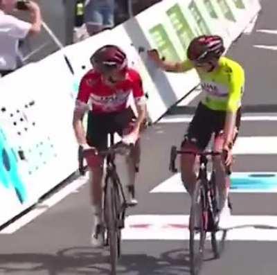 cyclists play rock, paper, scissors at the finish line to decide who wins