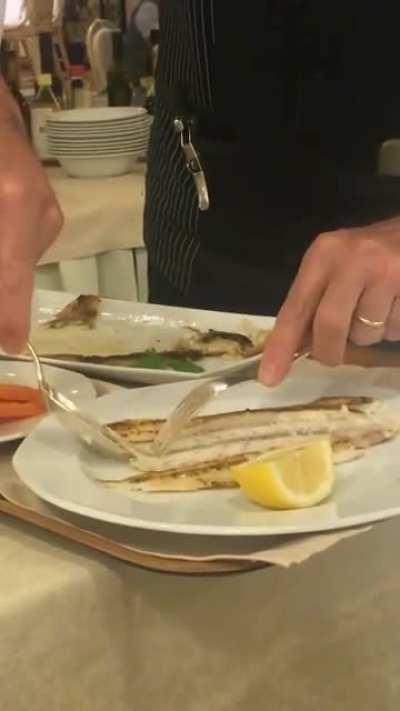 Waiter removes fish bones.