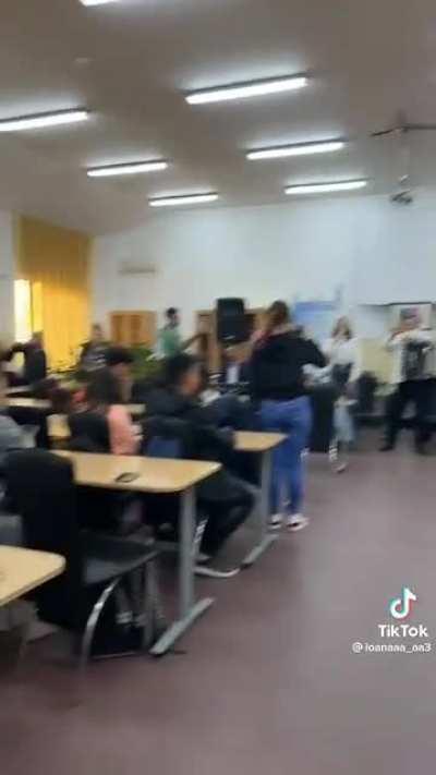 A young high school girl sings in front of the class in Romania