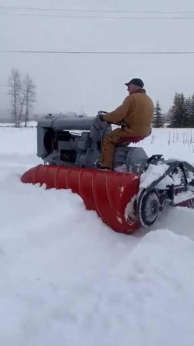 Modified Tractor with 2 screw patterned cylinders to propel through heavy snow