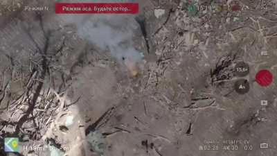  Russians drop an incendiary grenade near UAF trench. Ukrainian soldier shovels dirt on it in attempt to put fire out, then is hit/hits by some type of explosive