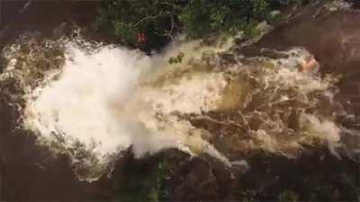 Man swimming near the top of a waterfall gets caught in a flash flood