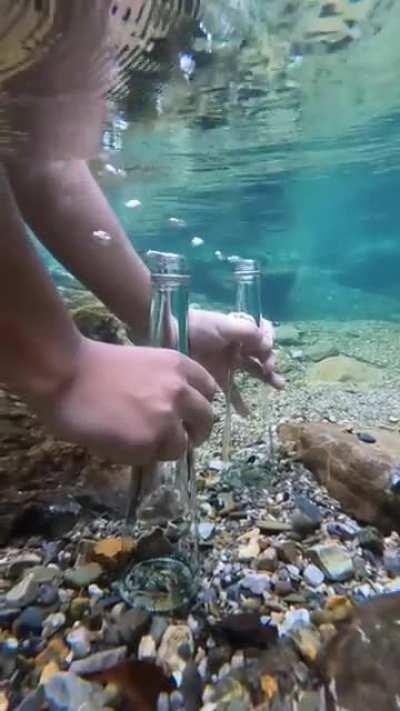 The bottle filling up underwater like it’s from a sink