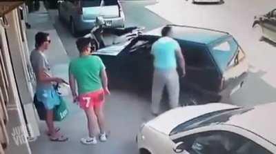 Man lifts car with pure strength to get out of a parking spot.