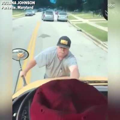 Guy jumps on hood of a school bus after a student threw a water bottle that hit his car