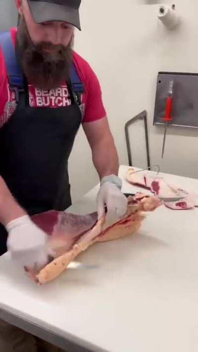 Butcher showing where the beef flank steak cutout is