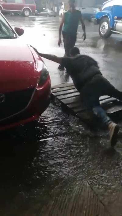 Boss didn't want to wet his shoes so he asked for the employee to put a pallet near the car door... and fell in the water