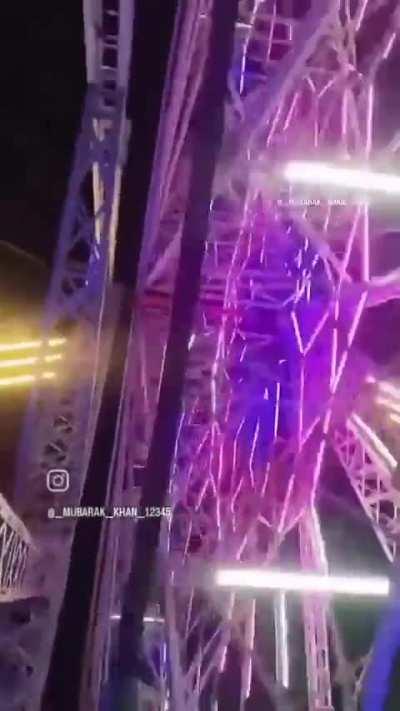 Someone climbing on a Ferris Wheel while its moving