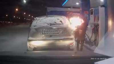 Using a lighter to see the gas pump nozzle