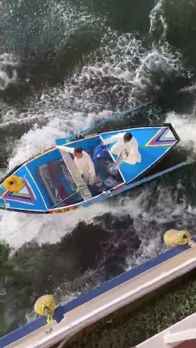 Egyptian vendors lassoing a moving cruise ship on the Nile River and trying to make money by selling their stuff. It's a high-stakes gamble in the bustling river trade.