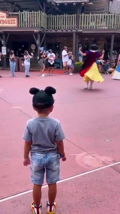 little boy tipping his hat to Disney princesses