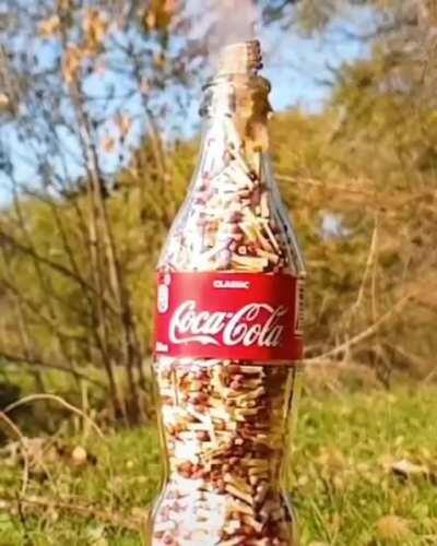 Glass coca cola bottle filled with wooden matches, ignited.