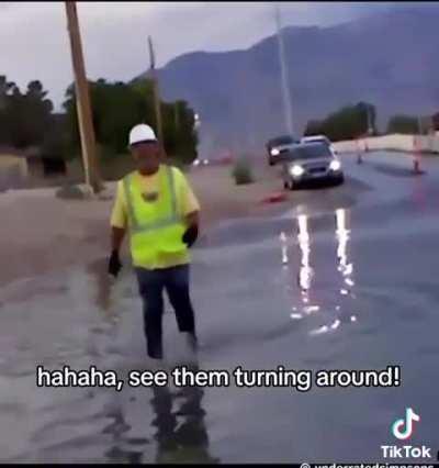 Worker makes traffic think puddle is deep