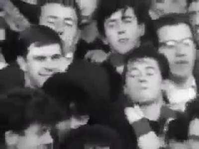 Liverpool supporters sing &quot;she loves you&quot; by The Beatles on the Kop in 1964