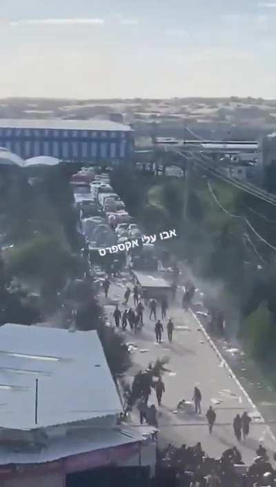 Hamas police members shooting at civilian Gazans near an aid truck.