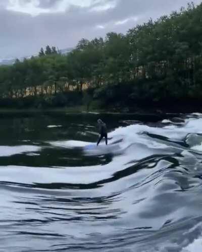 Surfing a river break in Norway