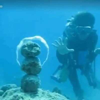 Diver making underwater vortex ring