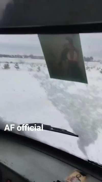 A Ukrainian military truck driver is happy with the job done by an improvised snow grader towed by an MT-LB APC.