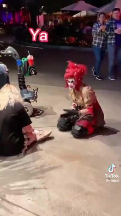 A clown giving a nice shoe tying lesson