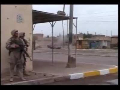 US Marines firing an M-203 grenade launcher at an abandoned car in Fallujah, Iraq (2004)