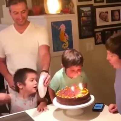 Kid tries to blow out thr birthday boy's candles, gets stopped by adult many times