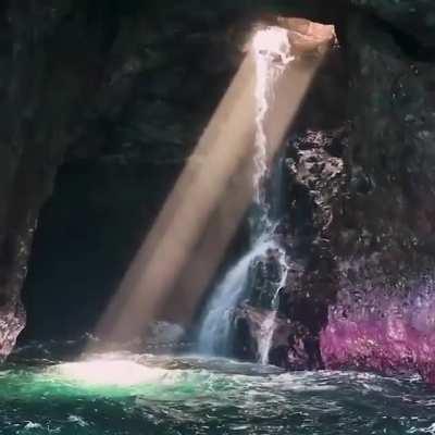 Jumping through a hole in the ceiling of the cave with waterfall.