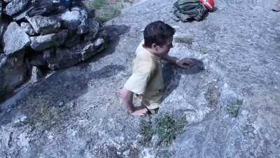 Man passes through a small entry to explore a cave.