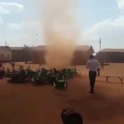 The way this dust devil breaks all the neatly packed rows of chairs.