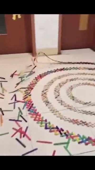 Guy sets off a chain reaction of sticks causing a cool pattern