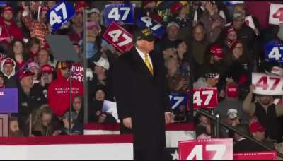 Trump arriving over three hours late to a rally, dressed in black, proceeds to make his followers listen to a nearly 10 min death march and more before speaking.