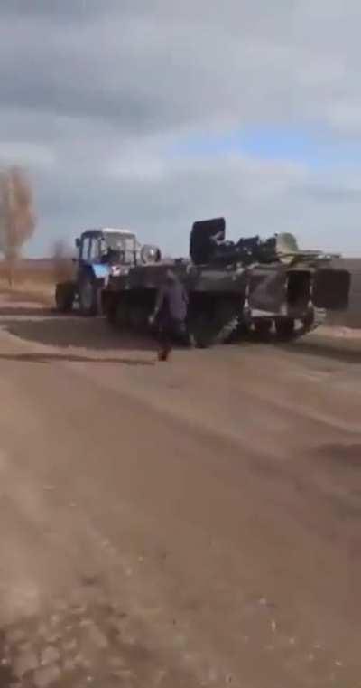 Ukrainian tractor taking a Russian MT-LB.