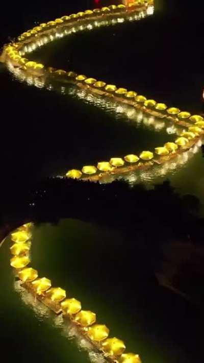 Glowing bamboo dragon chasing the pearl over the Yulong River