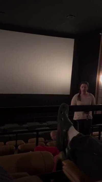 Man refuses to change assigned seat in movie theater.