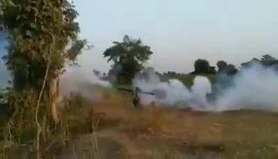 A young Burmese guerilla fighter firing a handmade weapon during a battle against Myanmar military in Mingin township, Myanmar on December