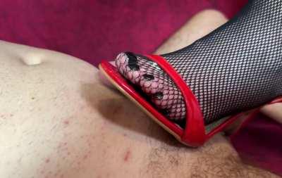 Trampling his cock in red high heels and fishnets